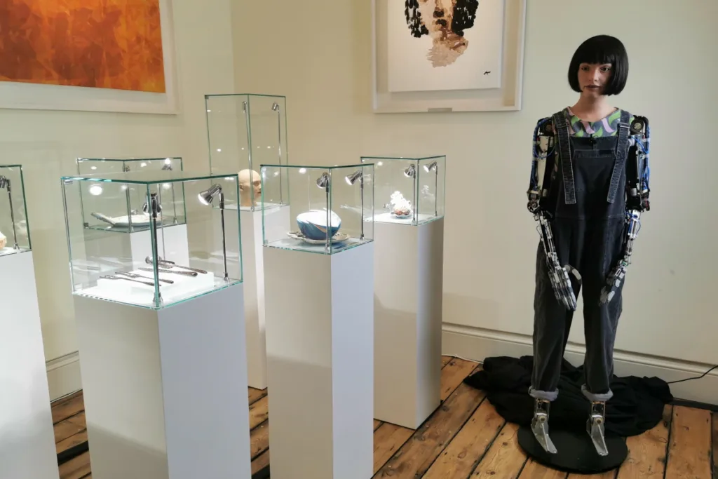 Humanoid robot Ai-Da stands by her pieces of art at the London Design Biennale