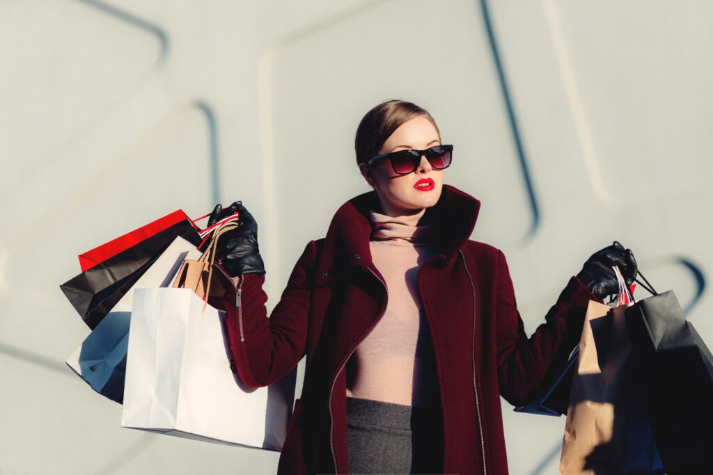 A young women holds several fashion shopping bags.